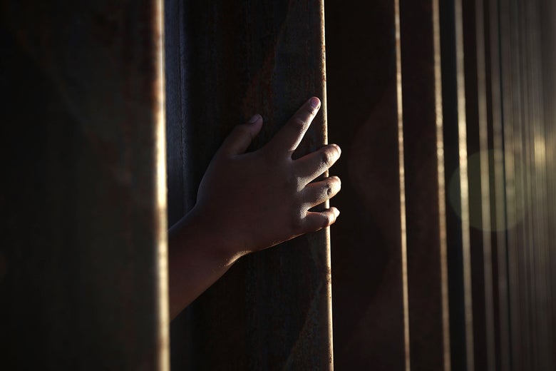 A child reaches through from the Mexican side of the U.S./Mexico border fence on June 24, 2018 in Sunland Park, New Mexico.